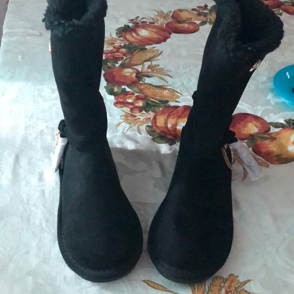 Black furry boots with ribbons and gold chain.